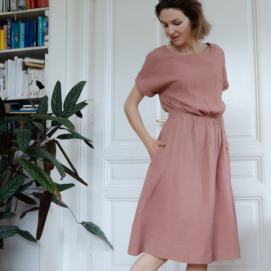 Frau in altrosa Musselinkleid mit kurzen Ärmeln, ausgestelltem Rock und Taschen; Urheber: Mini & Eve