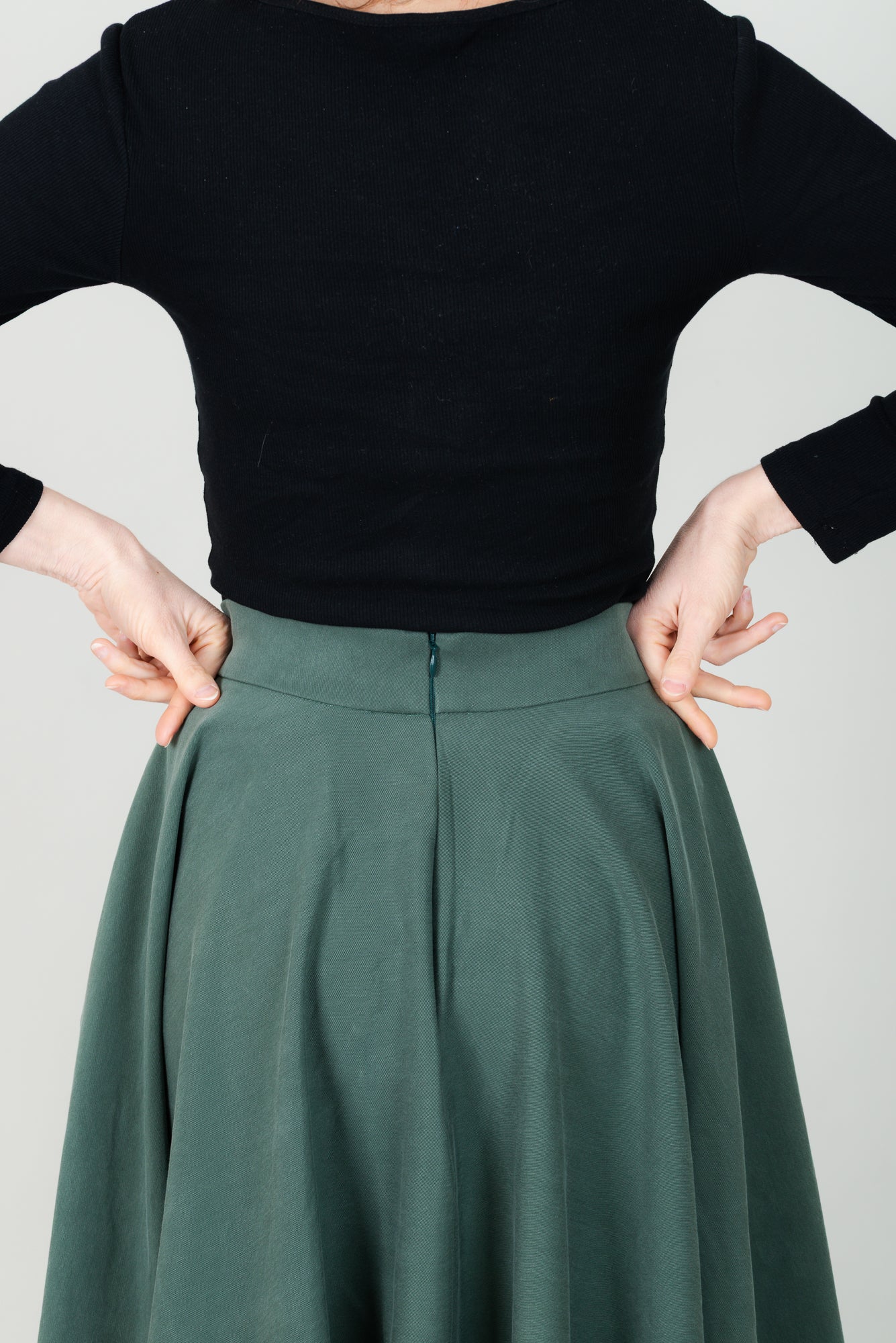 Frau in Tencel-Tellerrock in der Farbe Kiefer Dunkelgrün mit Taschen; Urheber: Mini & Eve