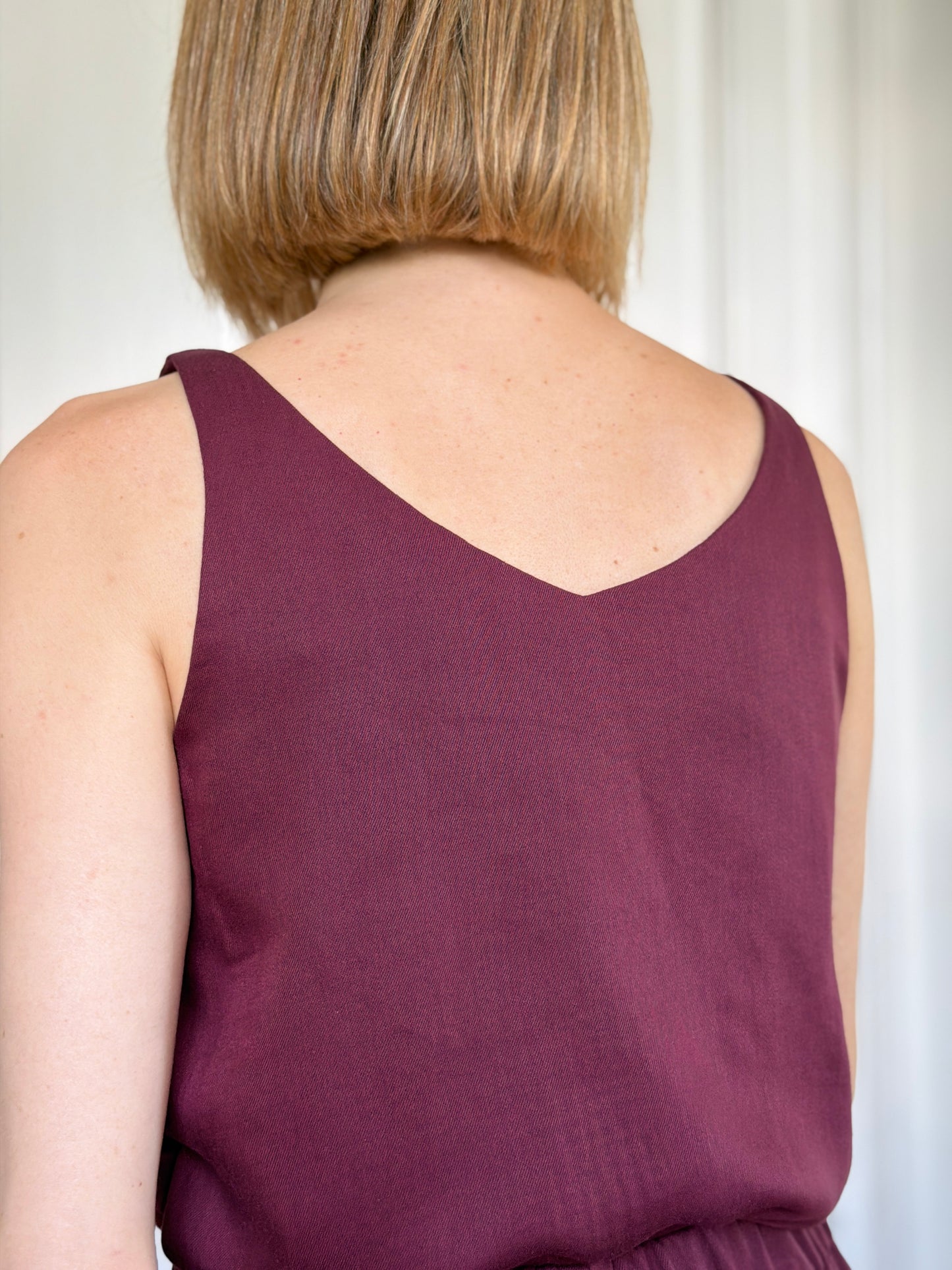 Frau in ärmellosem Trägershirt aus Tencel in Bordeaux Rot Rückenansicht; Urheber: Mini & Eve