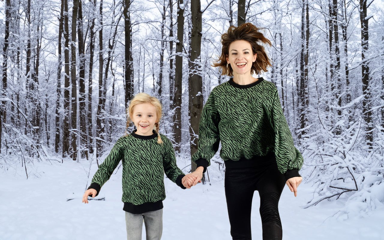 Mutter und Tochter im Partnerlook mit warmen Pullis im grünen Zebrastreifen-Look