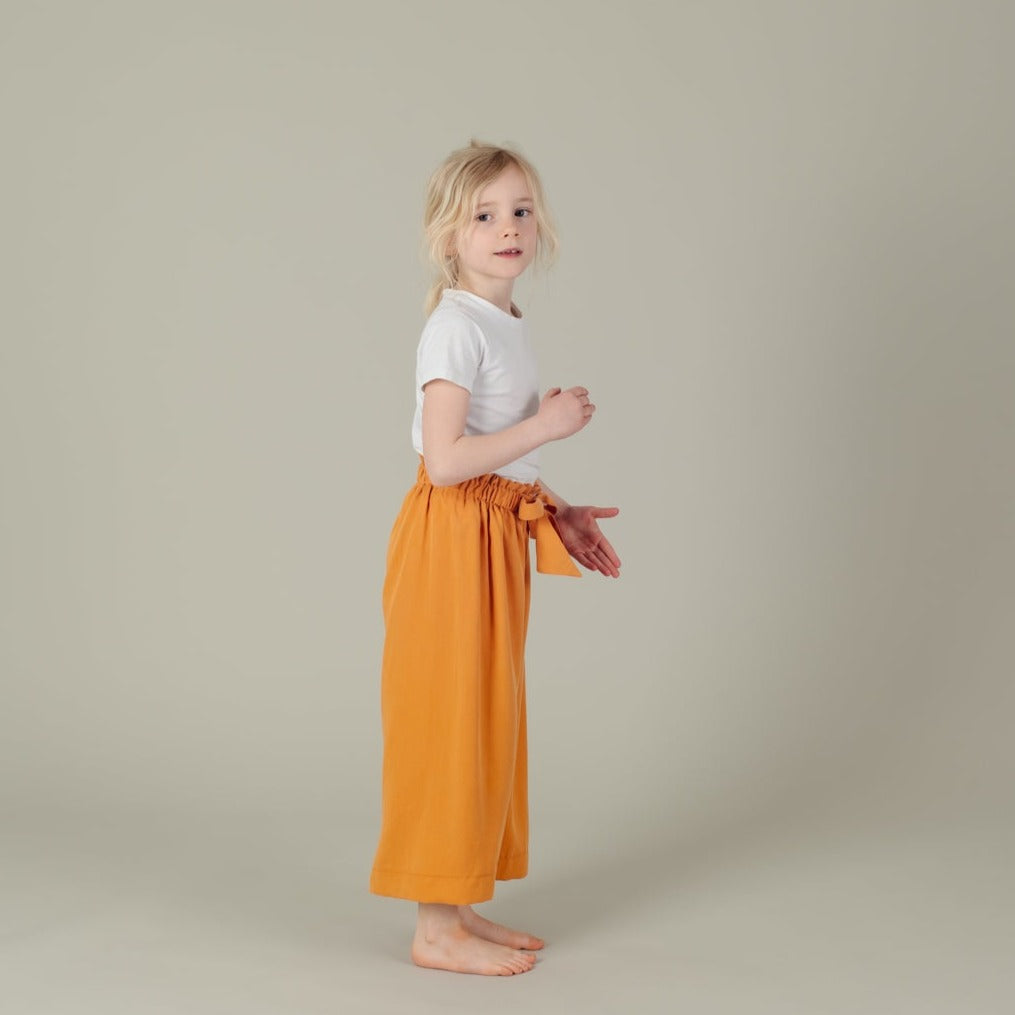 Tencel Kinderhose mit Paperbag-Bund und Schleife in der Farbe Mango, Urheber: Mini & Eve