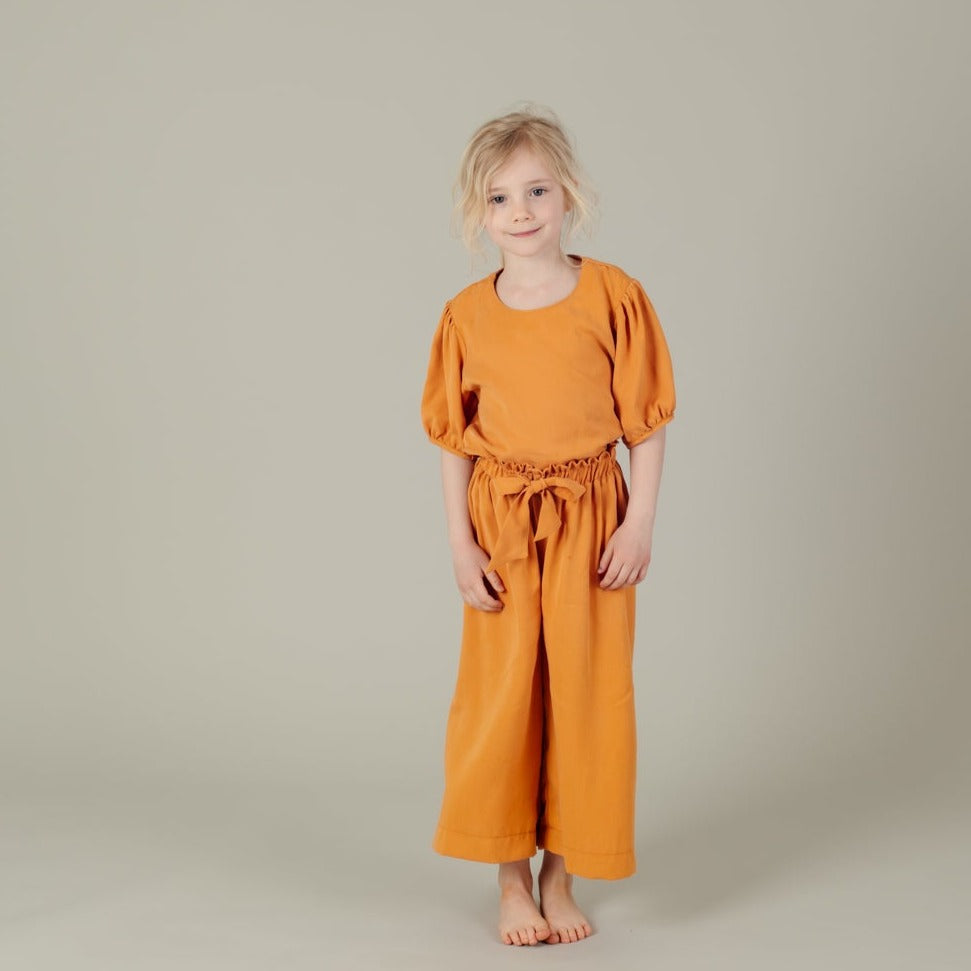 Tencel Kinderhose mit Paperbag-Bund und Schleife in der Farbe Mango, Urheber: Mini & Eve