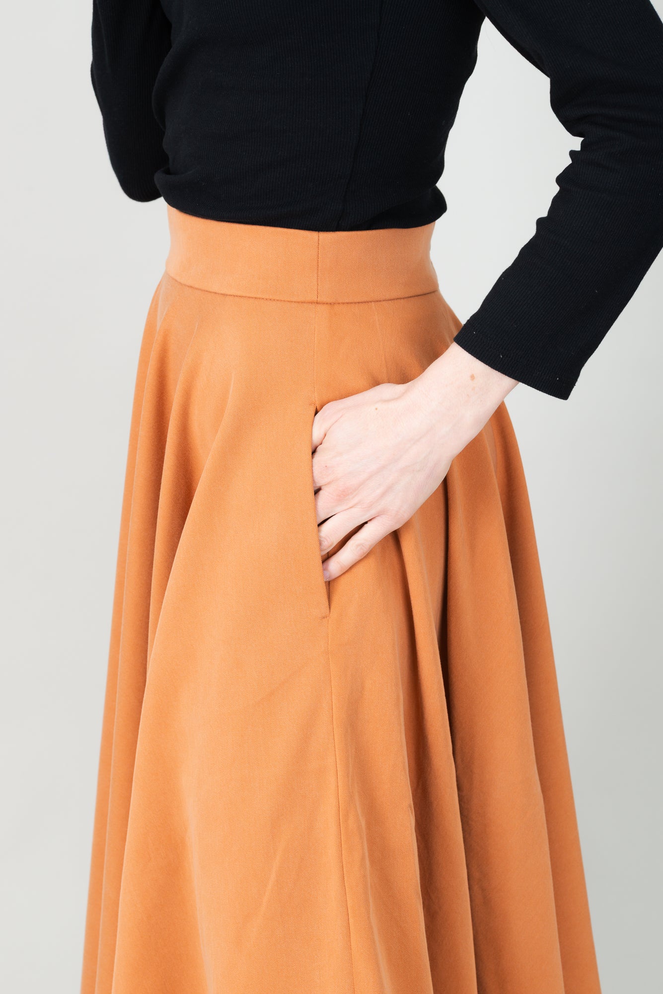 Frau in Tencel-Tellerrock Drehrock in der Farbe Karamell mit Taschen; Urheber: Mini & Eve