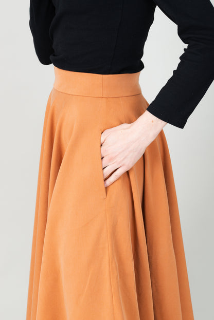 Frau in Tencel-Tellerrock Drehrock in der Farbe Karamell mit Taschen; Urheber: Mini & Eve