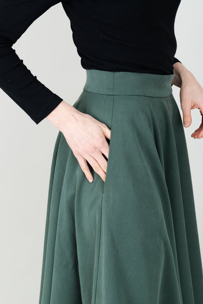 Frau in Tencel-Tellerrock in der Farbe Kiefer Dunkelgrün mit Taschen; Urheber: Mini & Eve