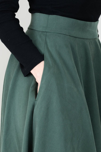 Frau in Tencel-Tellerrock in der Farbe Kiefer Dunkelgrün mit Taschen; Urheber: Mini & Eve