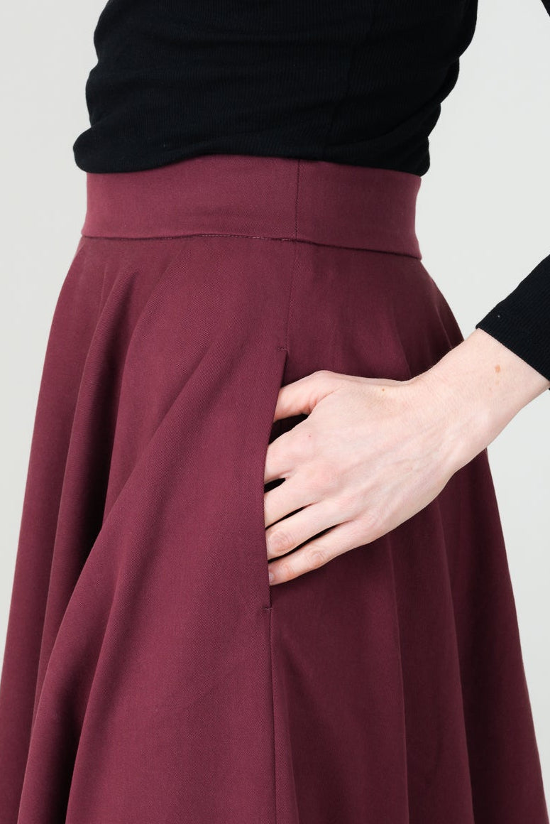 Frau in Tencel-Tellerrock in der Farbe Bordeaux Rot mit Taschen; Urheber: Mini & Eve