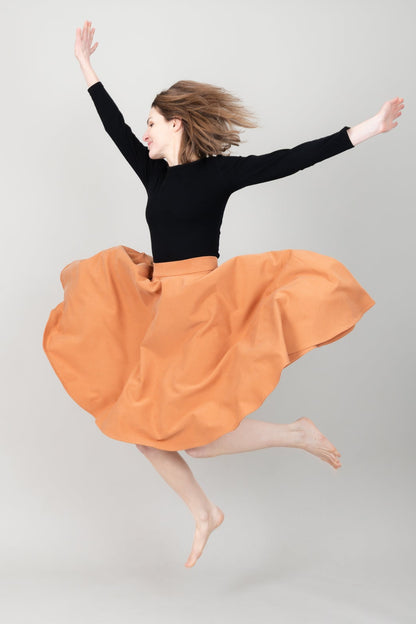 Frau in Tencel-Tellerrock Drehrock in der Farbe Karamell mit Taschen; Urheber: Mini & Eve