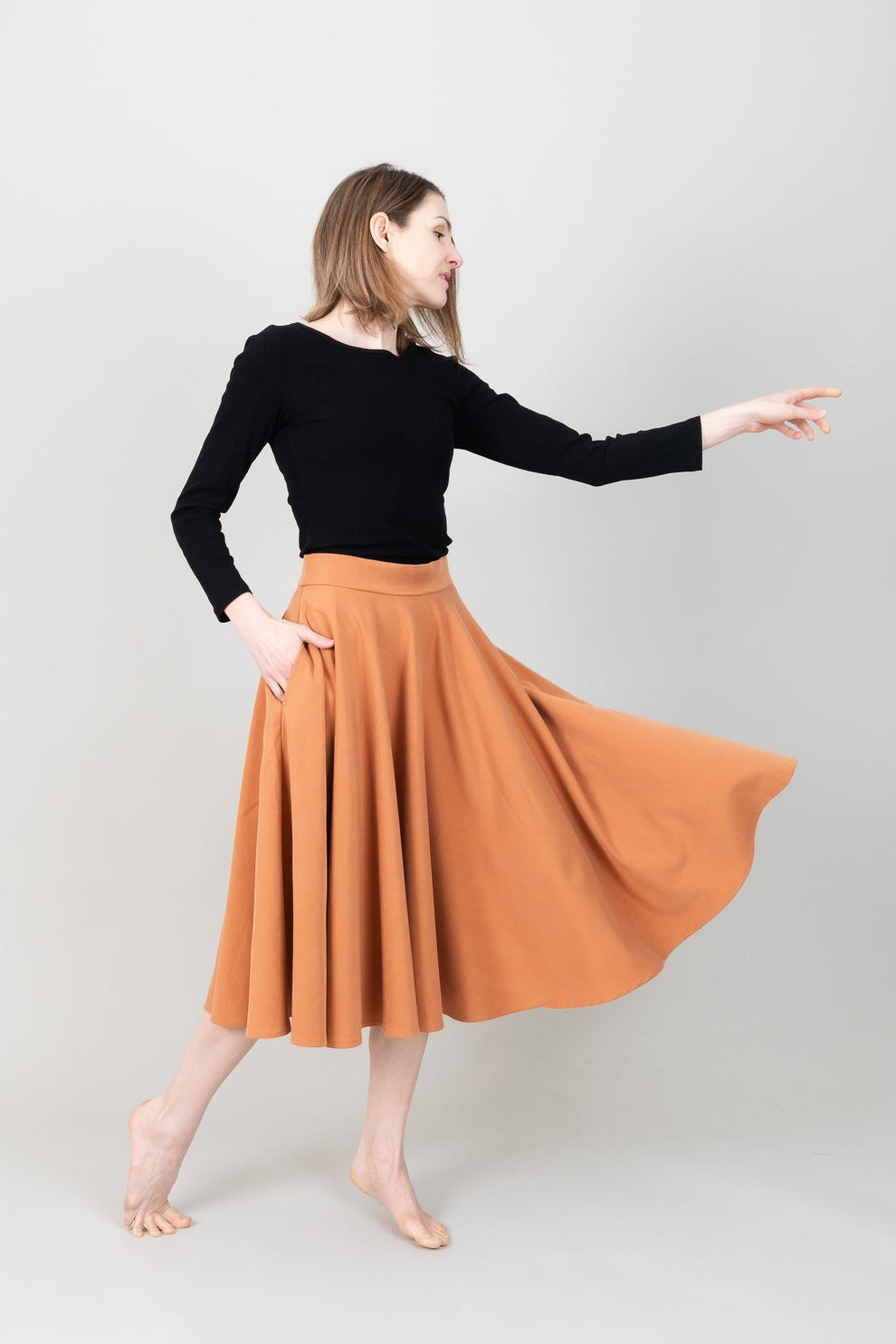 Frau in Tencel-Tellerrock Drehrock in der Farbe Karamell mit Taschen; Urheber: Mini & Eve