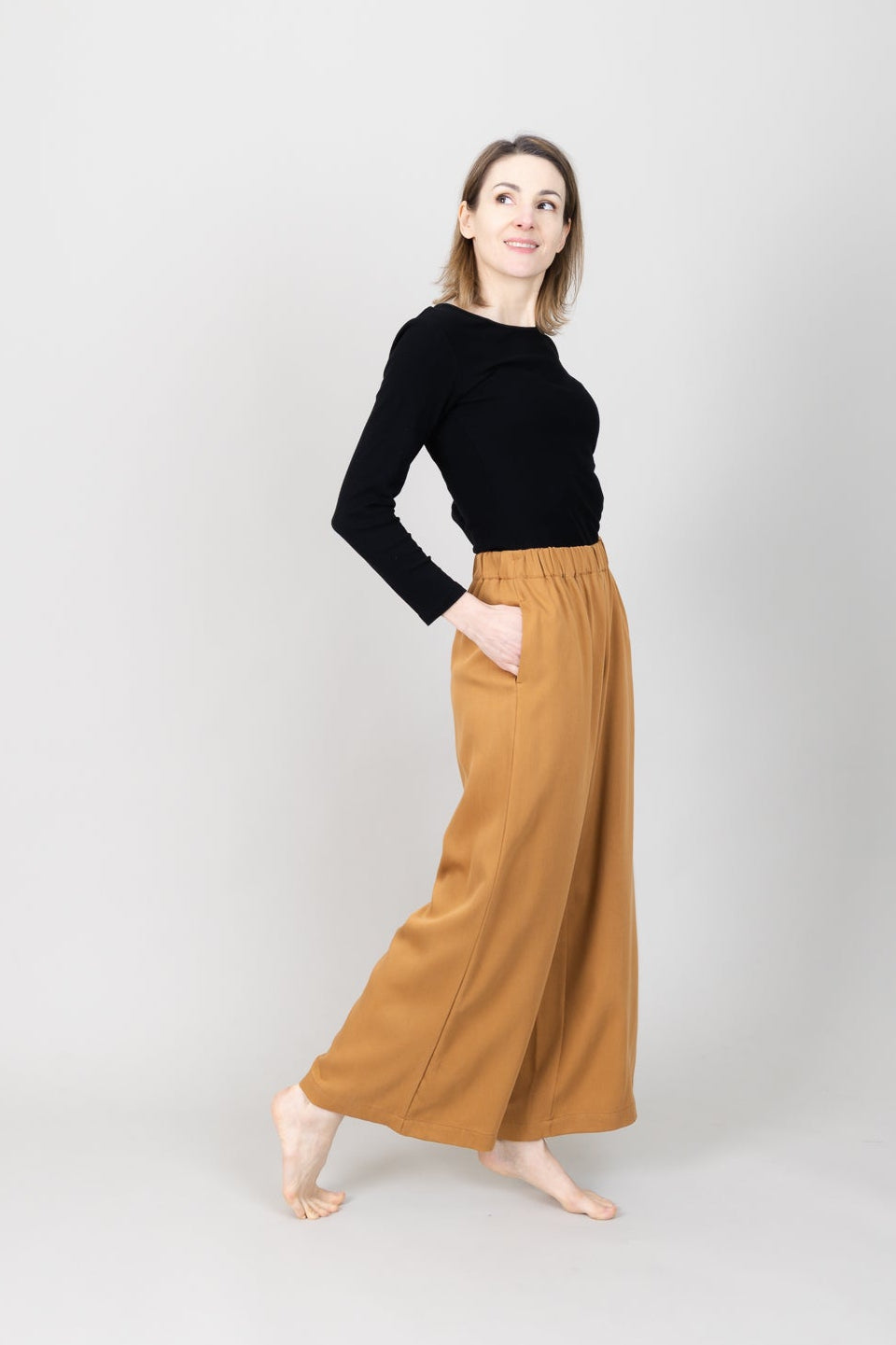 Frau in Tencel-Hose in der Farbe Senf mit Taschen; Urheber: Mini & Eve