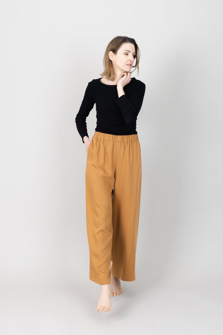 Frau in Tencel-Hose in der Farbe Senf mit Taschen; Urheber: Mini & Eve