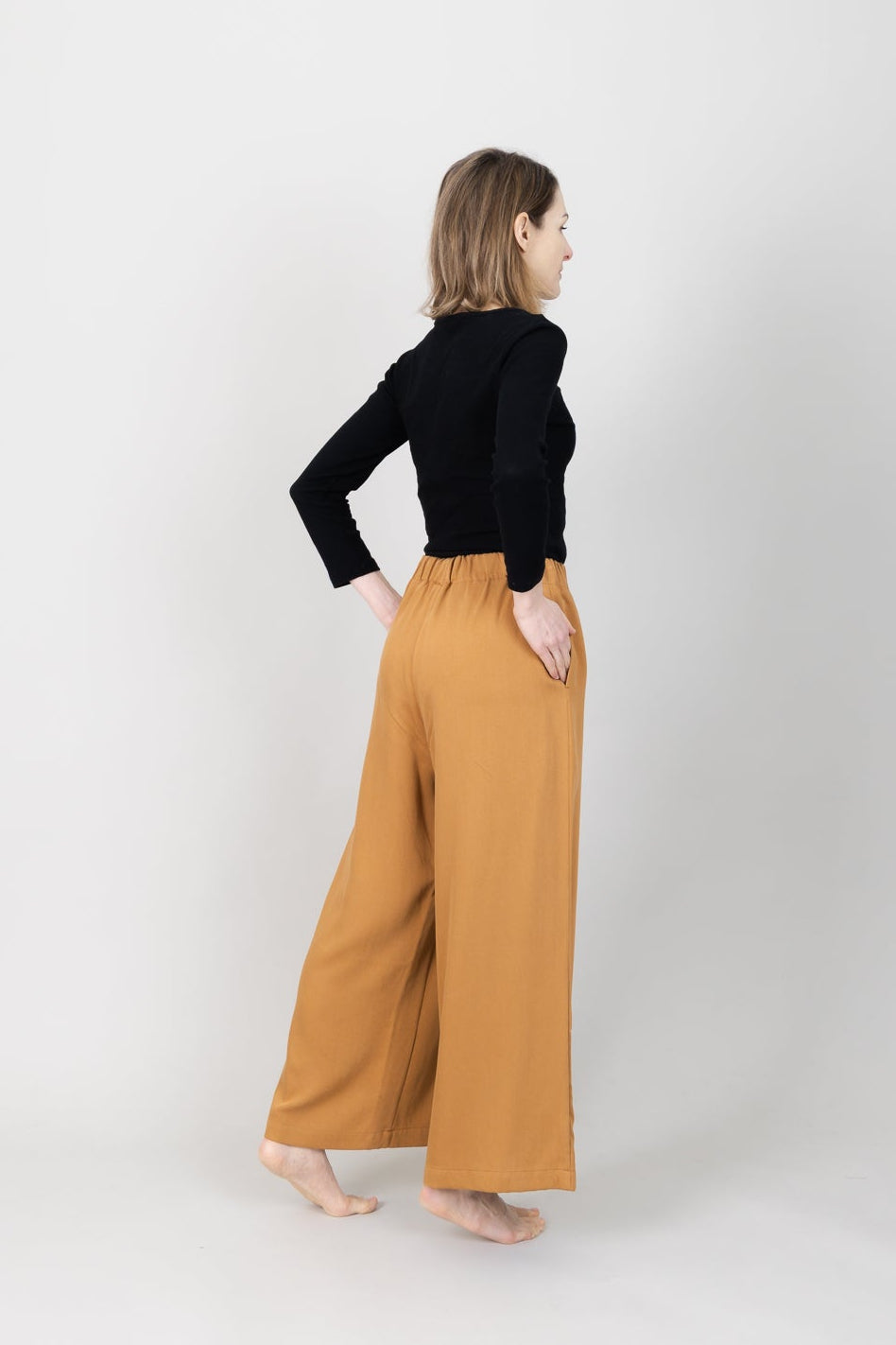 Frau in Tencel-Hose in der Farbe Senf mit Taschen; Urheber: Mini & Eve