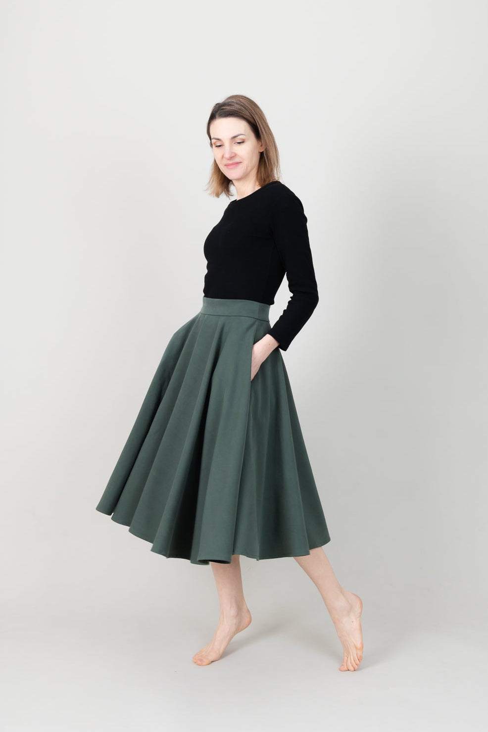Frau in Tencel-Tellerrock in der Farbe Kiefer Dunkelgrün mit Taschen; Urheber: Mini & Eve