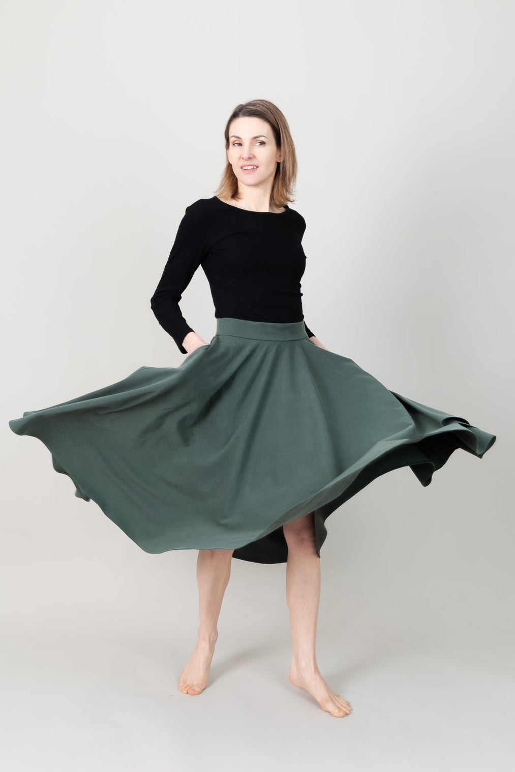 Frau in Tencel-Tellerrock in der Farbe Kiefer Dunkelgrün mit Taschen; Urheber: Mini & Eve