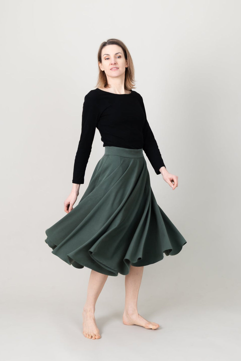 Frau in Tencel-Tellerrock in der Farbe Kiefer Dunkelgrün mit Taschen; Urheber: Mini & Eve