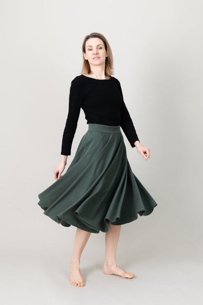 Frau in Tencel-Tellerrock in der Farbe Kiefer Dunkelgrün mit Taschen; Urheber: Mini & Eve