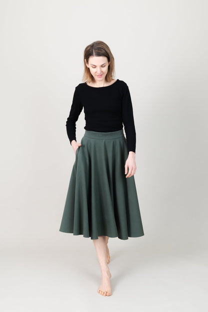 Frau in Tencel-Tellerrock in der Farbe Kiefer Dunkelgrün mit Taschen; Urheber: Mini & Eve