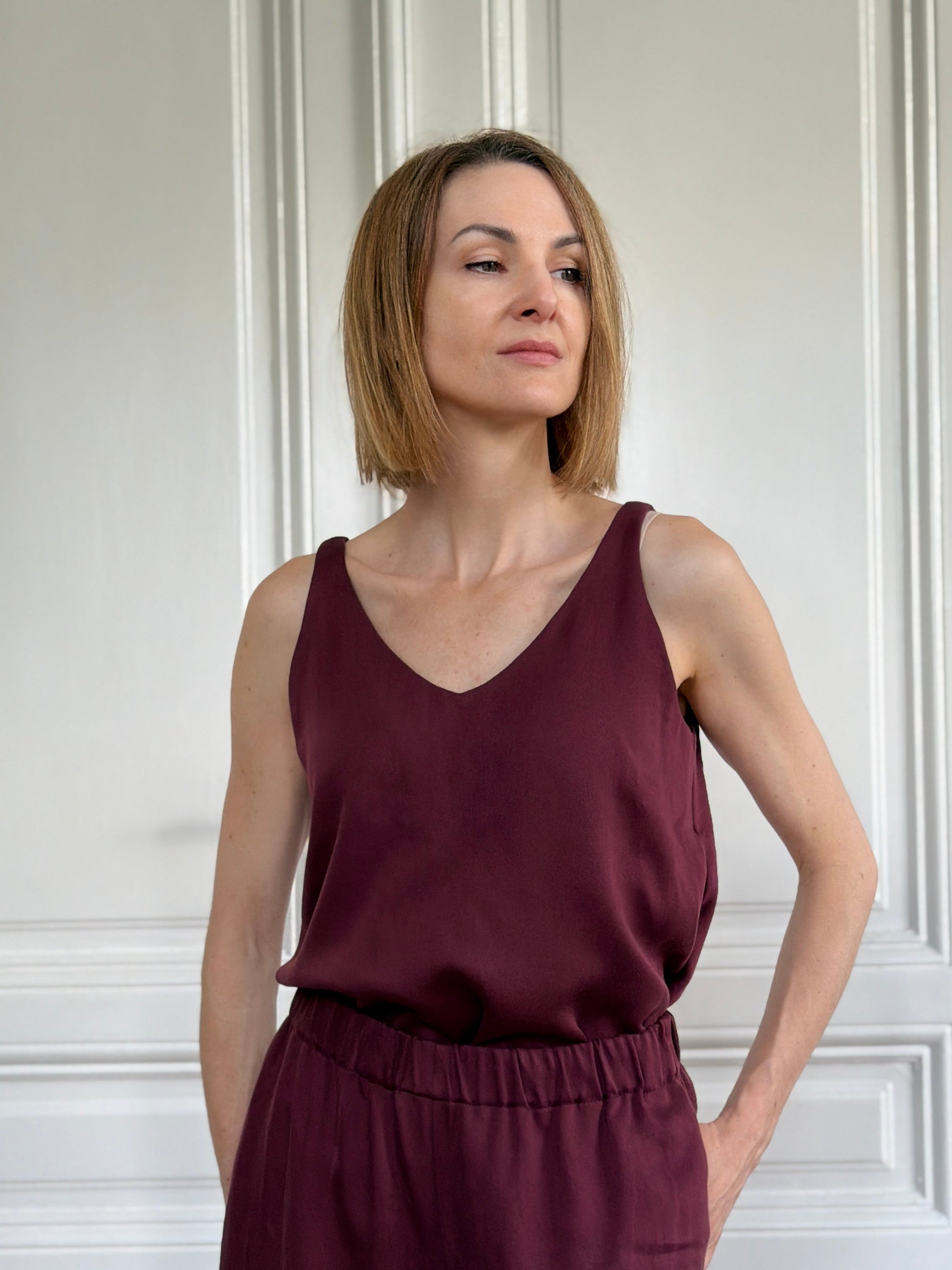 Frau in ärmellosem Trägershirt aus Tencel in Bordeaux Rot mit passender Hose; Urheber: Mini & Eve