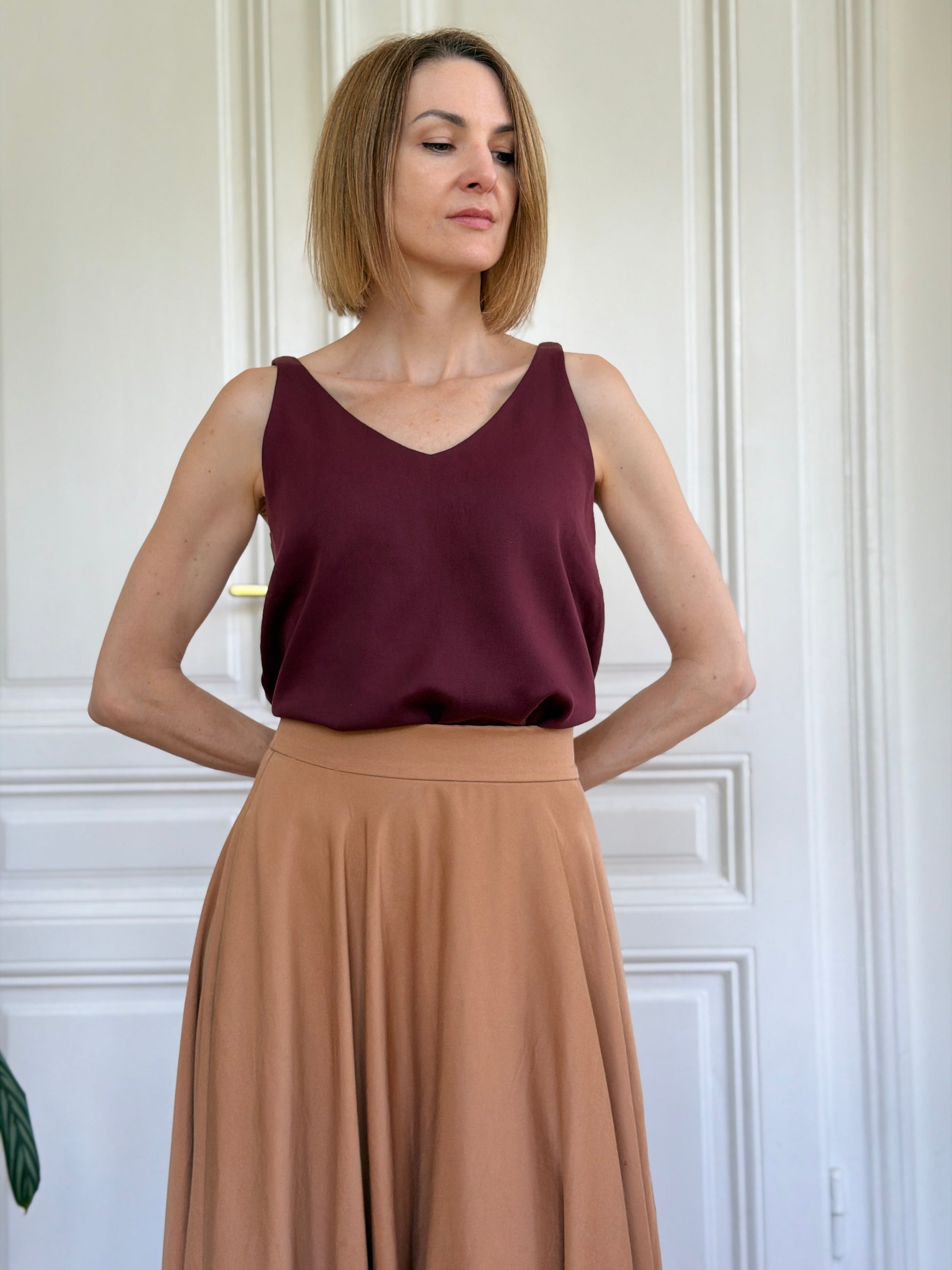 Frau in ärmellosem Trägershirt aus Tencel in Bordeaux Rot und Tellerrock; Urheber: Mini & Eve