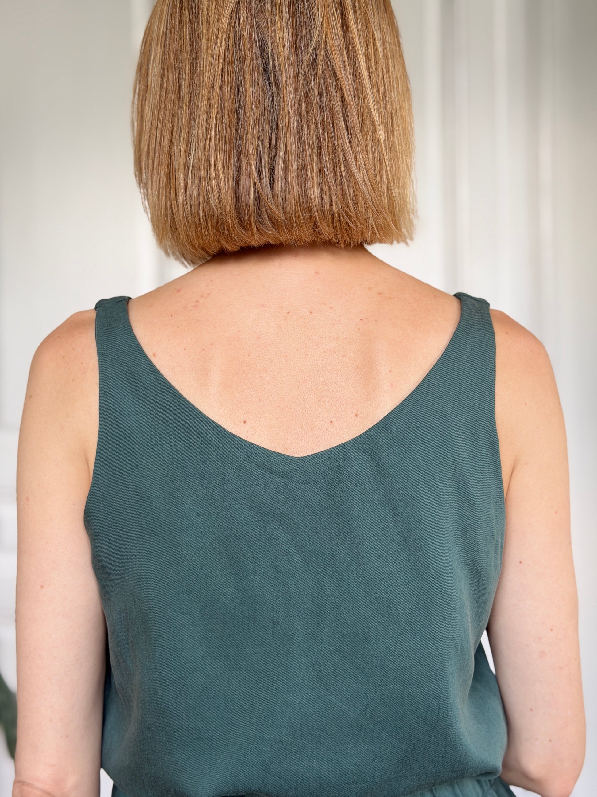 Frau in kiefergrünem / dunkelgrünem Trägershirt aus Tencel Rückenansicht; Urheber: Mini & Eve